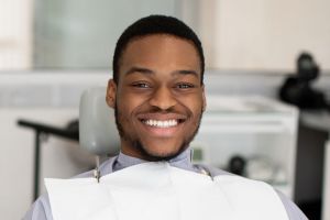 Smiling young man seated at orthodontics appointment